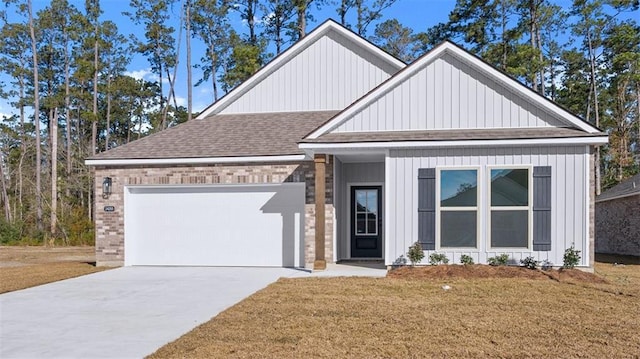 view of front of property with concrete driveway, a front yard, a shingled roof, and an attached garage