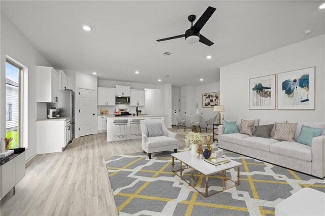 living area with visible vents, ceiling fan, light wood-style flooring, and recessed lighting