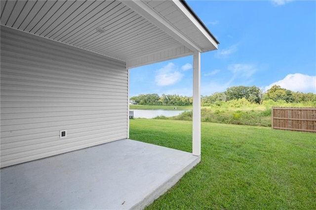 view of yard featuring fence, a water view, and a patio