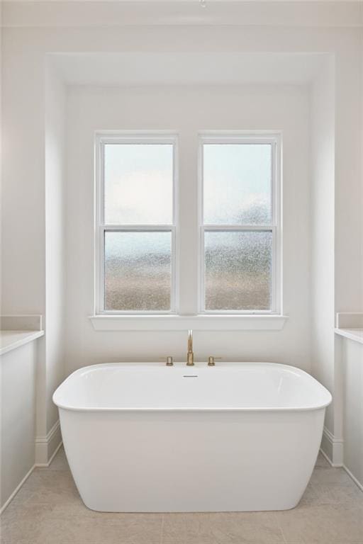 bathroom with a bathing tub and tile patterned flooring