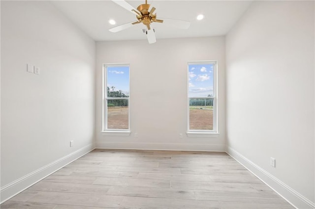 empty room featuring a wealth of natural light, ceiling fan, and light hardwood / wood-style floors