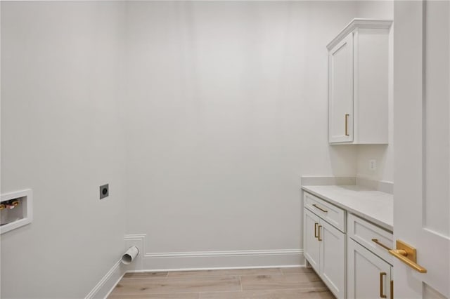 laundry area with cabinets, light hardwood / wood-style floors, hookup for a washing machine, and electric dryer hookup