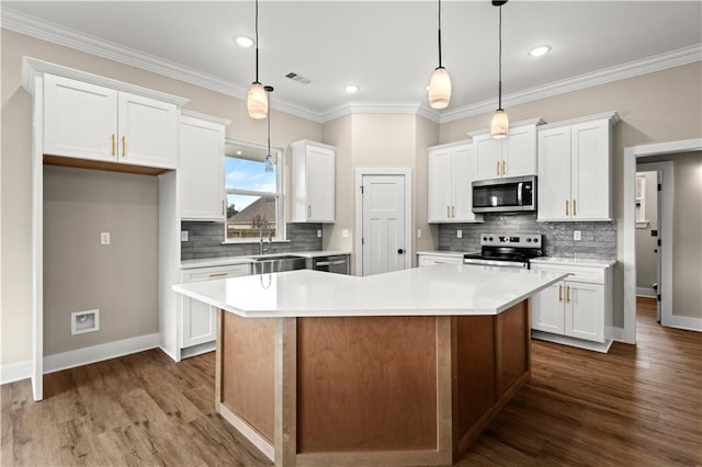 kitchen featuring dark wood-type flooring, a kitchen island, white cabinetry, and appliances with stainless steel finishes