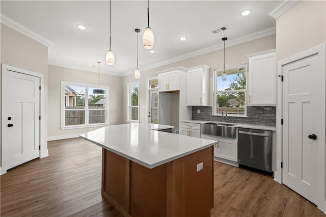 kitchen featuring dark wood-type flooring, white cabinets, sink, stainless steel dishwasher, and a kitchen island