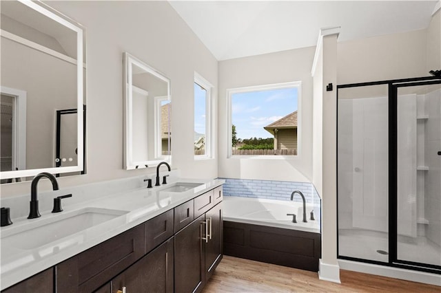 bathroom with vanity, hardwood / wood-style floors, vaulted ceiling, and separate shower and tub