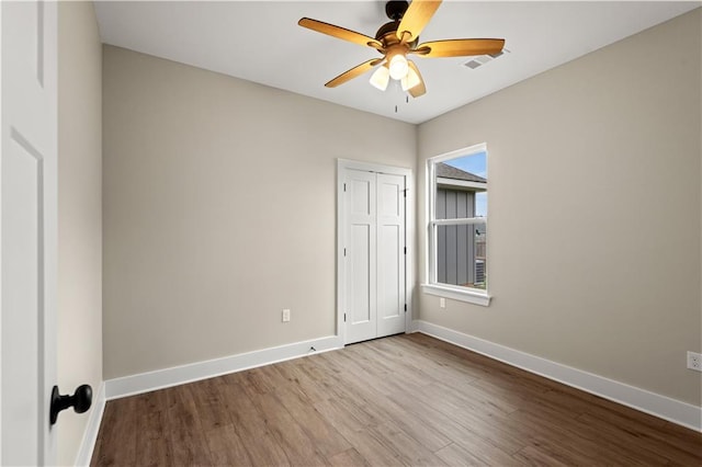 empty room with ceiling fan and light hardwood / wood-style floors