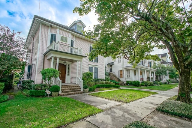 view of front of house with a front yard and a balcony