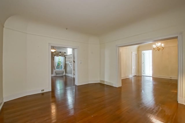 unfurnished room with dark wood-type flooring and a notable chandelier