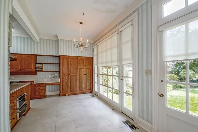 entryway featuring a wealth of natural light, a notable chandelier, crown molding, and beam ceiling