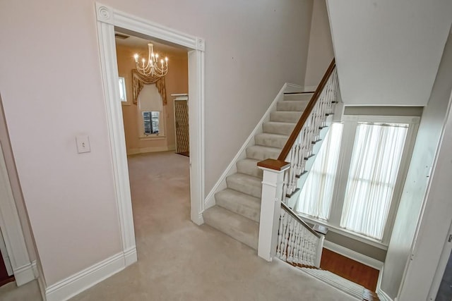 1521 Dufossat St, New Orleans, LA 70115 - stairs featuring a chandelier, baseboards, and carpet floors
