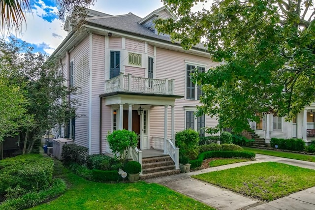 view of front of home with a front lawn and a balcony