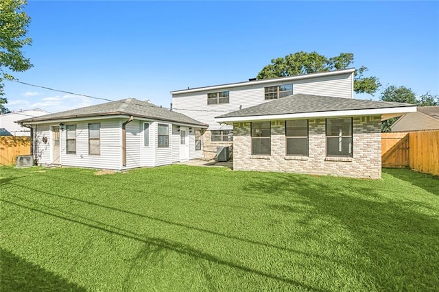 back of property with a lawn and central air condition unit