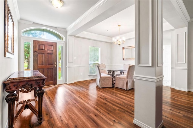 entryway featuring ornamental molding, dark wood-type flooring, and a chandelier