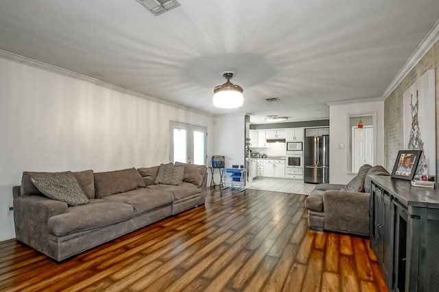 living room with crown molding, wood-type flooring, and french doors