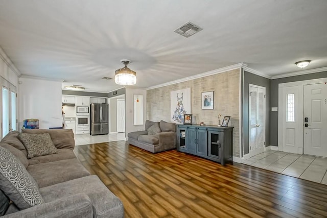 living room featuring crown molding and light hardwood / wood-style floors