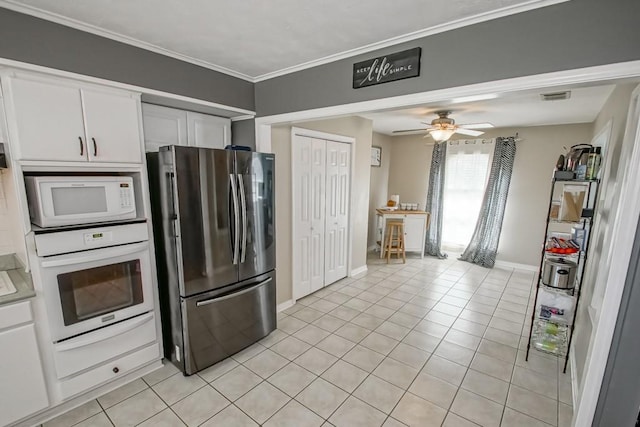 kitchen with white appliances, light tile patterned floors, ornamental molding, ceiling fan, and white cabinets