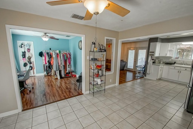 interior space with sink, plenty of natural light, white cabinets, and light tile patterned flooring