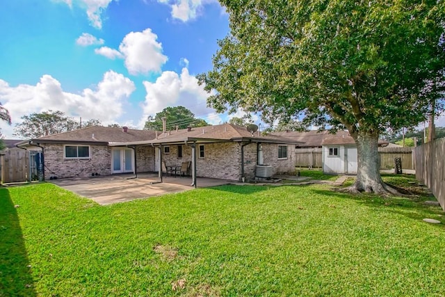 back of property with a shed, central AC unit, a lawn, and a patio