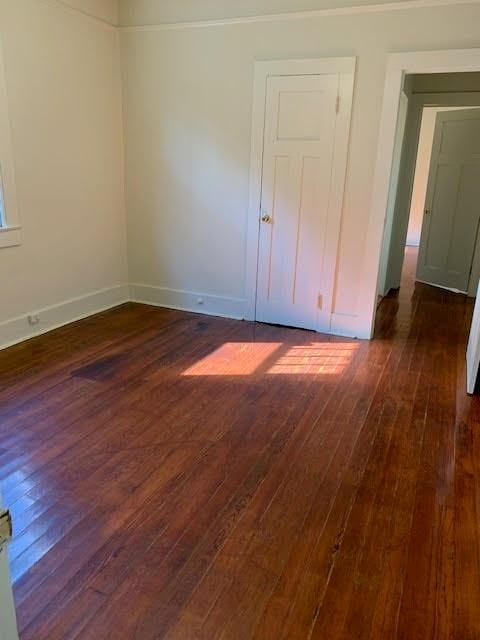 unfurnished room with dark wood-type flooring