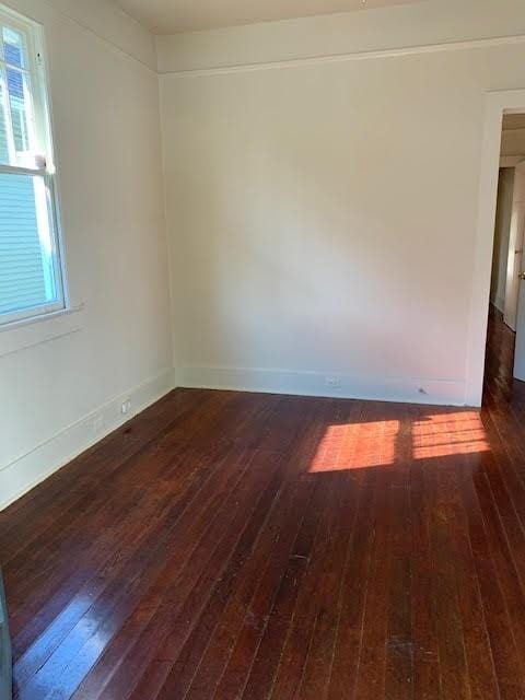 spare room with plenty of natural light and dark hardwood / wood-style floors