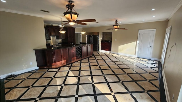 kitchen featuring dark brown cabinets, black fridge, and crown molding