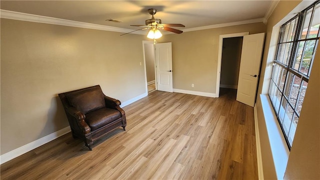 living area featuring light hardwood / wood-style flooring, ceiling fan, and crown molding