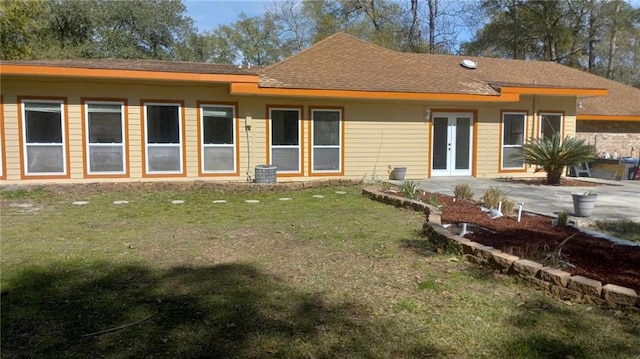 rear view of property with a patio area, a lawn, and french doors