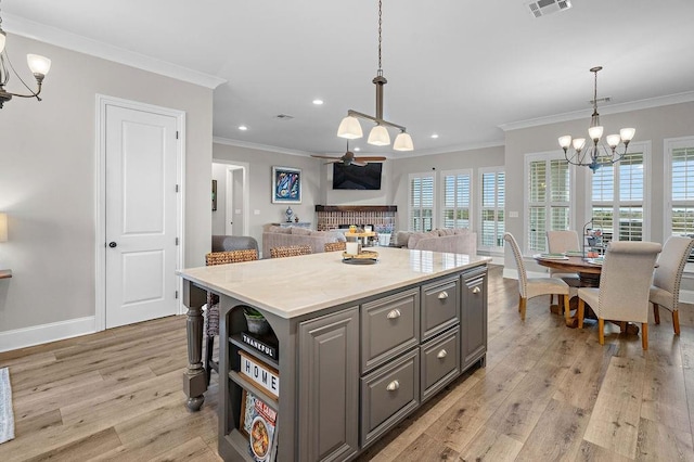 kitchen featuring crown molding, light hardwood / wood-style floors, and a center island