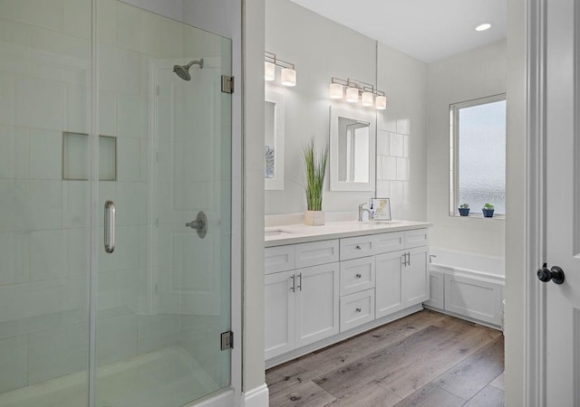 bathroom featuring independent shower and bath, wood-type flooring, and vanity