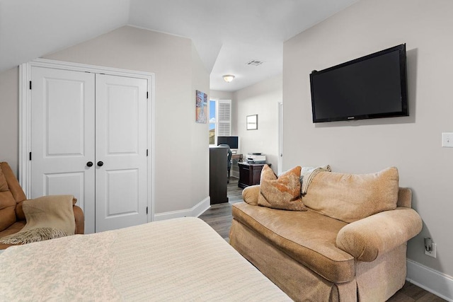 bedroom with dark wood-type flooring, a closet, and lofted ceiling