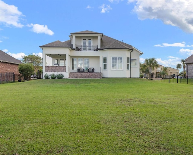 rear view of property with a patio, a lawn, ceiling fan, and a balcony