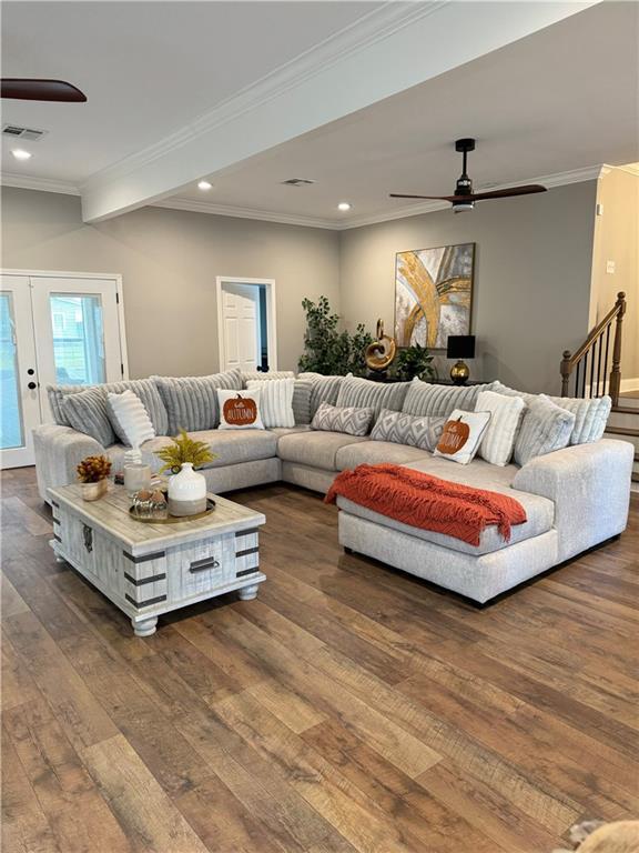 living room with ceiling fan, dark hardwood / wood-style floors, and ornamental molding