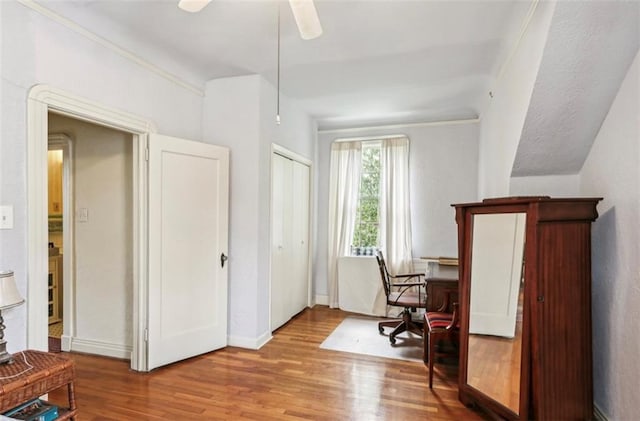 office space with ornamental molding, ceiling fan, and light hardwood / wood-style floors