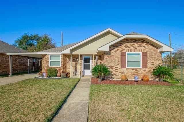 single story home featuring a front lawn and a carport