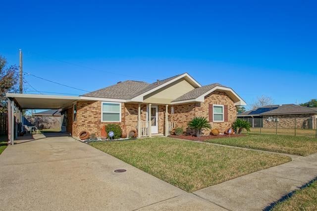 ranch-style house featuring a front yard and a carport