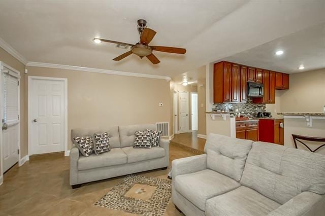 living room featuring ceiling fan and crown molding