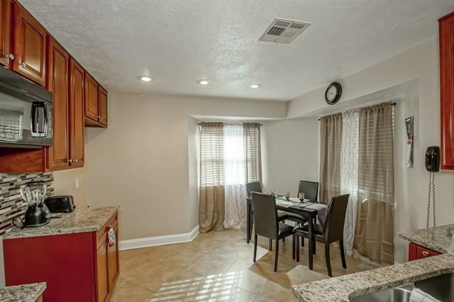 kitchen featuring light stone countertops, a textured ceiling, light tile patterned flooring, and tasteful backsplash