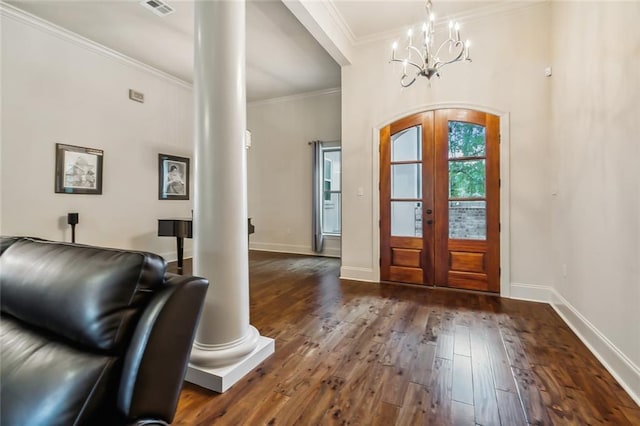 entrance foyer with ornate columns, french doors, an inviting chandelier, dark hardwood / wood-style floors, and crown molding