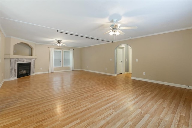 unfurnished living room with ceiling fan, light wood-type flooring, and ornamental molding