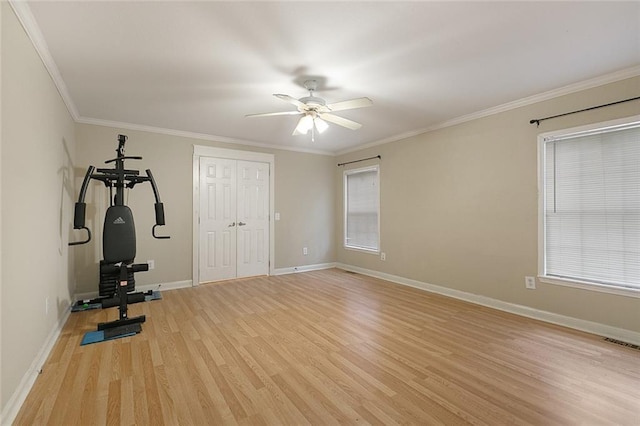 workout room with crown molding, baseboards, visible vents, light wood-style floors, and ceiling fan