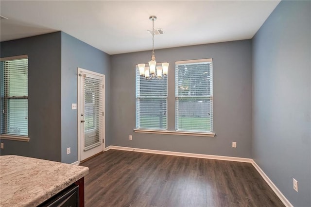 unfurnished dining area featuring dark hardwood / wood-style floors and an inviting chandelier