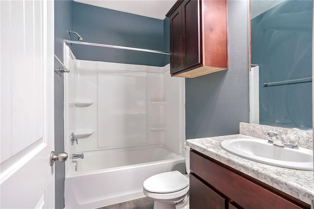 full bathroom featuring washtub / shower combination, hardwood / wood-style flooring, vanity, and toilet