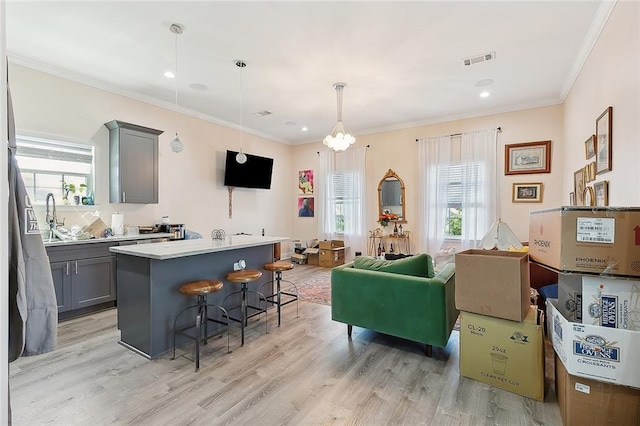 interior space with gray cabinets, plenty of natural light, pendant lighting, and a center island