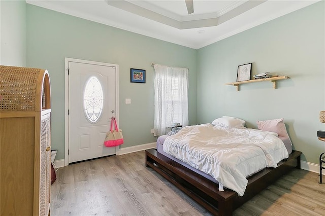 bedroom with crown molding, light hardwood / wood-style flooring, multiple windows, and ceiling fan