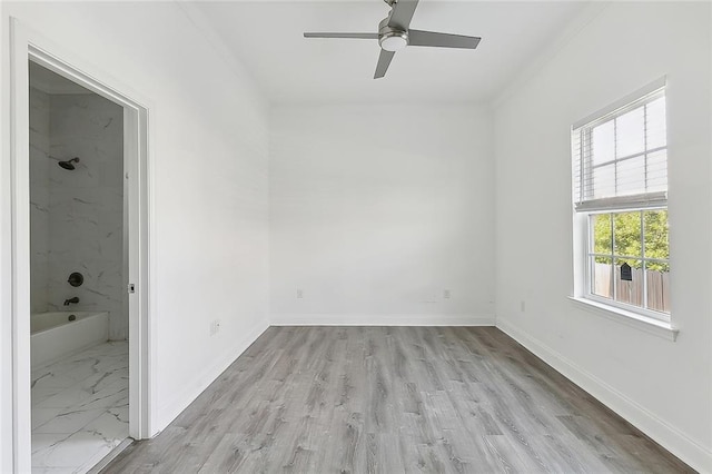 spare room featuring ornamental molding, light hardwood / wood-style floors, a healthy amount of sunlight, and ceiling fan