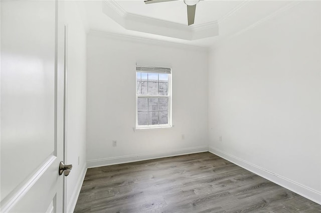 spare room with ceiling fan, a tray ceiling, wood-type flooring, and ornamental molding