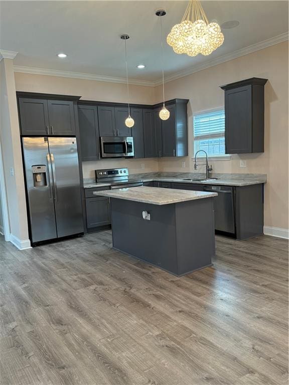 kitchen with light hardwood / wood-style flooring, hanging light fixtures, and stainless steel appliances