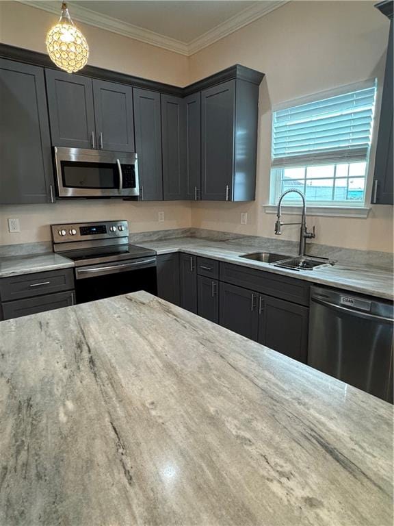 kitchen featuring sink, light stone counters, appliances with stainless steel finishes, hanging light fixtures, and crown molding