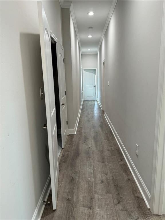 corridor with dark hardwood / wood-style flooring and ornamental molding