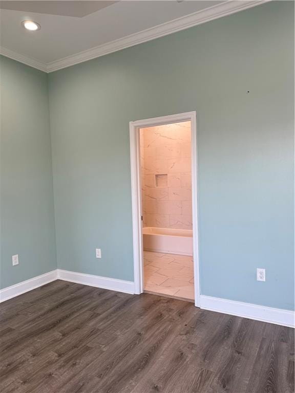 spare room featuring ornamental molding and dark wood-type flooring